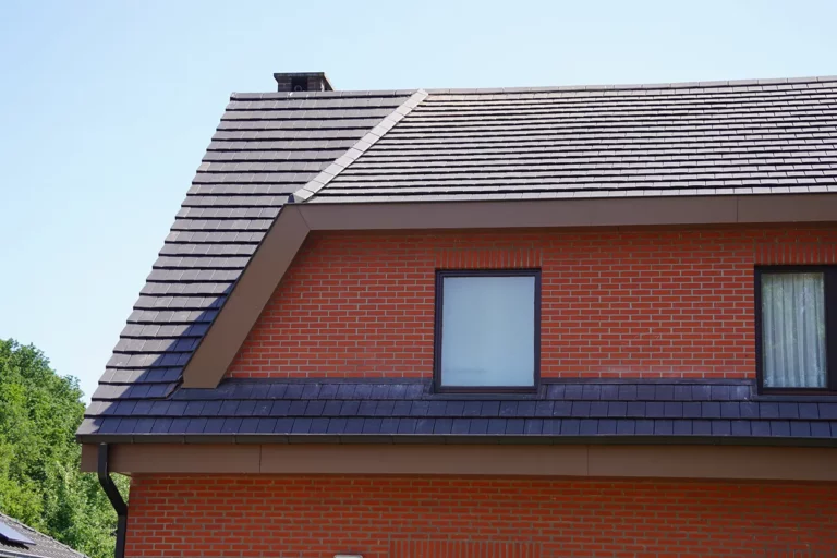 Een nieuw dak met Koramic Vauban-pannen en nieuwe zinken vierkante hanggoten. De dakoversteken zijn afgewerkt met Cedral board.